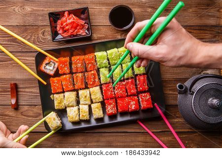 Sushi Set rolls with soy sauce served on black plate on wooden background
