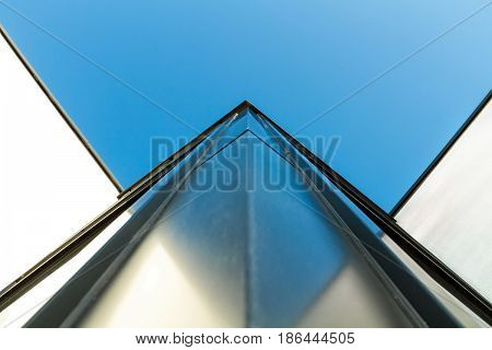 Corner detail of a modern building facade on a bright sunny day with clear sky. Abstract background. Space for text
