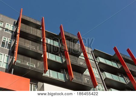 Residential modern Apartment Building with red vertical featured balconies. View looking up