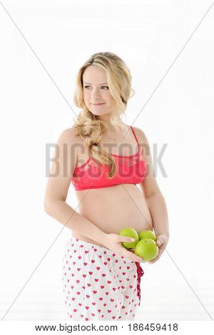 blonde Pregnant woman healthy eating green apple