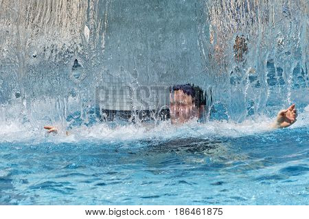 Woman at spa under waterfall shower. relaxing and wellness