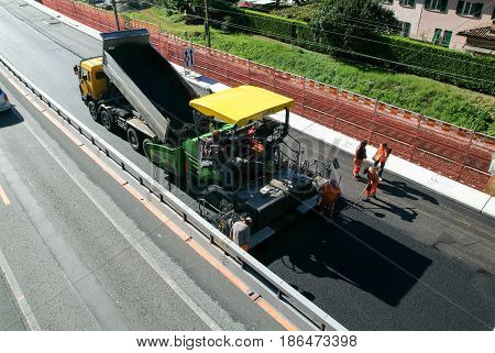 Workers And Vehicles During The Asphalting Of The Highway