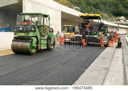Workers And Vehicles During The Asphalting Of The Highway