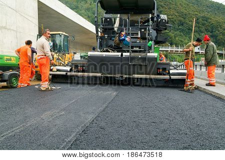 Workers And Vehicles During The Asphalting Of The Highway