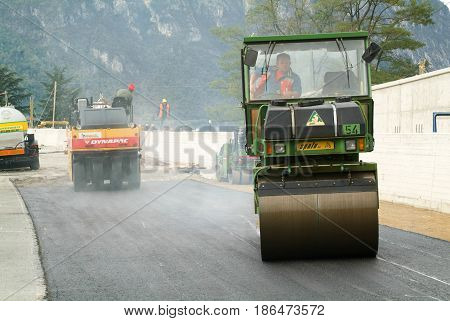 Workers And Vehicles During The Asphalting Of The Highway