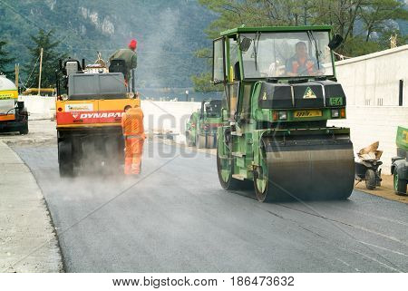 Workers And Vehicles During The Asphalting Of The Highway