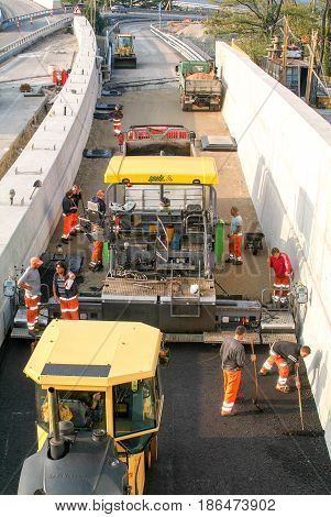 Workers And Vehicles During The Asphalting Of The Highway