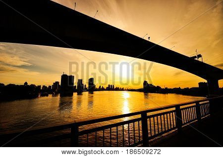 The solid picture of the river bridge in the big city at sunrise.