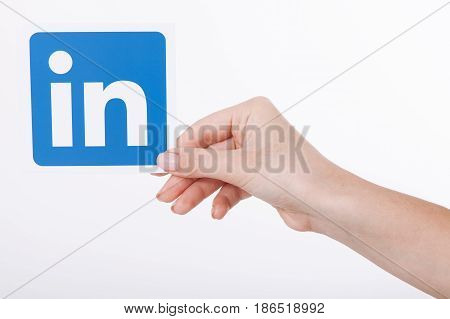 KIEV, UKRAINE - August 22, 2016: Woman hands holding Linkedin icon sign printed on paper on white background. Linkedin is a business social networking service.