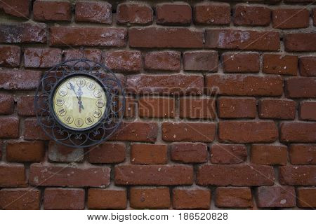 A Vintage Station Clock On A Red Brick Wall.