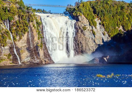  Montmorency Falls Park, close to the center of Old Quebec. Powerful waterfall Montmorency. Sunny autumn day. The concept of active and cultural tourism