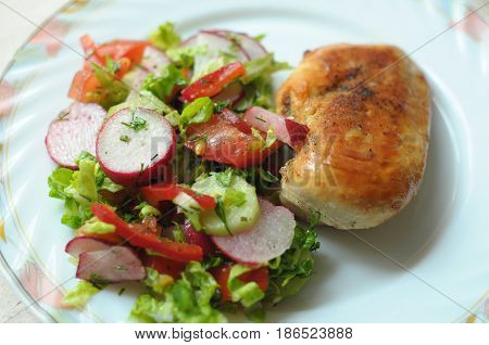 Baked Chicken Breast With Vegetable Salad On A White Plate