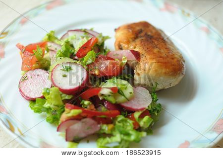 Baked Chicken Breast With Vegetable Salad On A White Plate