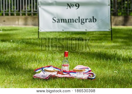 BERLIN - MAY 09 2016: Victory Day in Treptower Park (Soviet war memorial). Mass grave of fallen soldiers and officers who liberated Berlin from the Nazis. Russian tradition at the grave - vodka black bread and cigarettes.