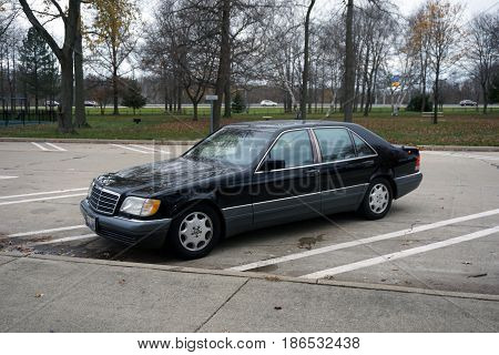 NEW BUFFALO, MICHIGAN / UNITED STATES - NOVEMBER 20, 2016: A black Mercedes Benz S-420 luxury sedan is parked in the parking lot of the New Buffalo Welcome Center 707 rest area.