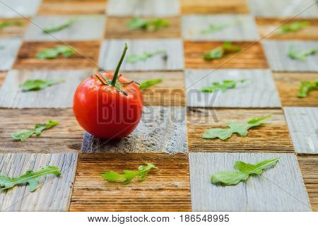 Fresh organic ripe tomatoes with water drops, basil leaves on surface mosaik board with pieces of different breeds as chess board background. Selective focus. Healthy eating concept, antioxidant and diet