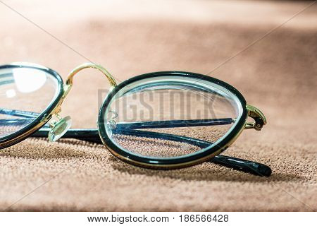 Blurred close-up a glasses on brown garment. selective focus and with a very shallow depth field.