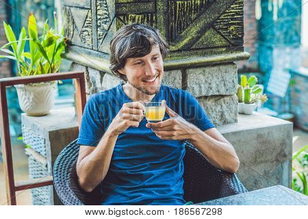 Young Man Sitting In A Cafe Drinking A Delicious Morning Ginger Tea In A Cafe