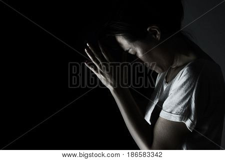 Depress Woman Praying In The Dark ( Praying In Secret Room Concept )