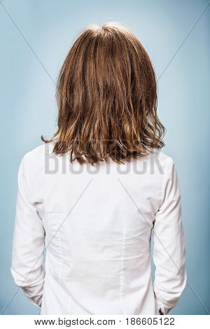 Back view of young woman with damaged fair hair over blue background.