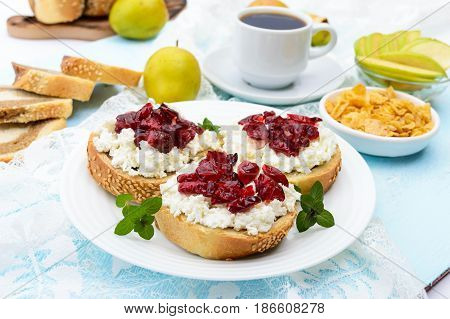 Delicious healthy breakfast: sandwiches with feta (cottage cheese) dried cranberries pears mint and a cup of coffee.