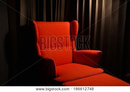 red chair and footrest in the dark room ,dark light