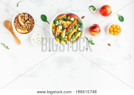 Breakfast with muesli peach salad fresh peaches on white background. Healthy food concept. Flat lay top view