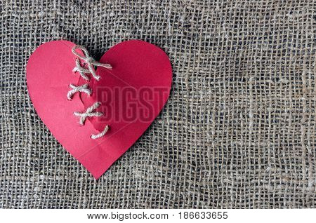 A broken red heart. Sewn thread. The concept of divorce separation quarrel.