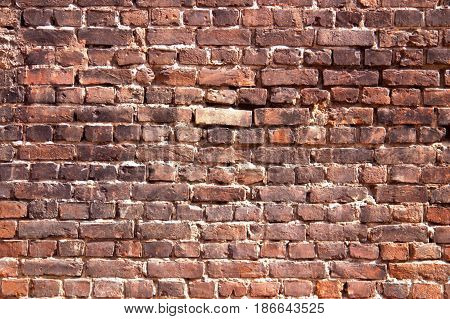 Red and black brick wall with traces of fire.