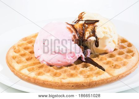 Vanilla and strawberry ice cream on a waffle and glazed with belgian chocolate sauce