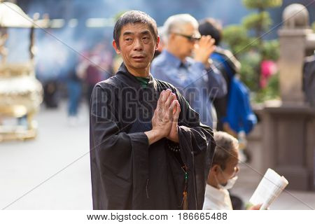TAIPEI, TAIWAN - MARCH 28, 2017 : A man is praying at the Lungshan Buddhist temple during a ceremony in Taipei, Taiwan