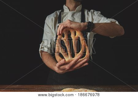 Baker holding fougas bread