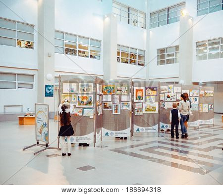 Udomlya City, Russia - 25 December 2015: Children watching the exhibition of drawings.