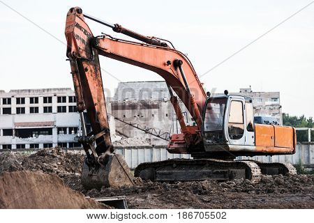Old rusty earth digging excavator machine working at building construction site