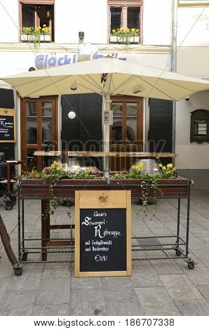 GRAZ, AUSTRIA - MARCH 19, 2017: Wooden flowerpot stand at the entrance of a resturant on Glockenspielplatz square in Graz the capital of federal state of Styria Austria.
