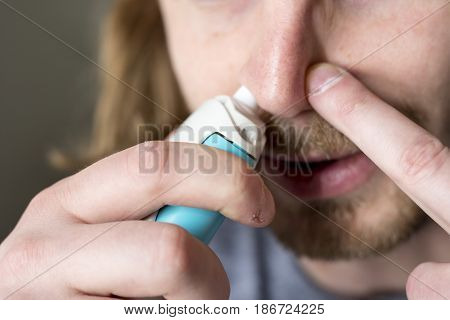 bearded young man and nose inhaler application