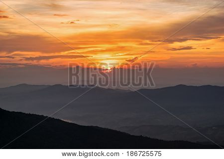 Beautiful landscape nature on mountain with sun cloud fog and bright colors of sky and sunlight during sunset in winter at view point Phu Chi Fa Forest Park in Chiang Rai Province Thailand