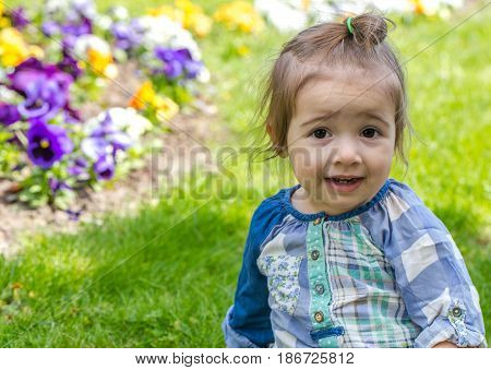 Little Cute Girl Sitting On The Grass