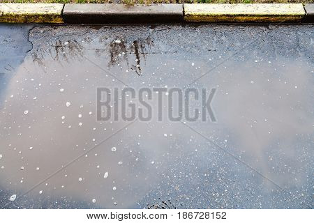 Dirty Puddle On Urban Streen In Rain