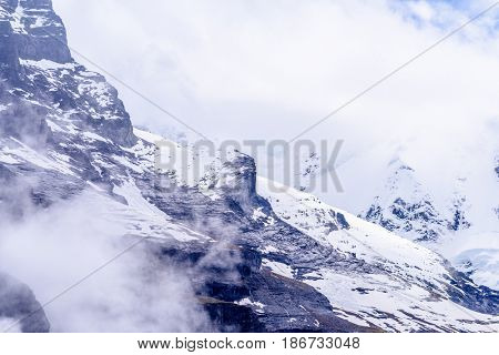 The Swiss Alps at Murren, Switzerland. Jungfrau Region. Tops of the mountains in fog and clouds.