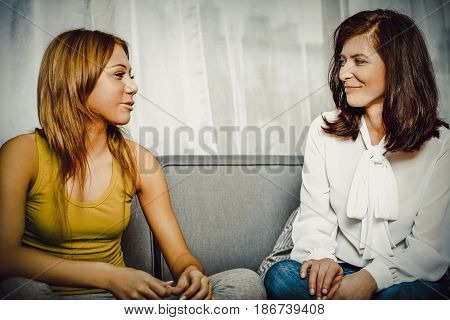 Mother and doughter sitting on sofa. Family time.