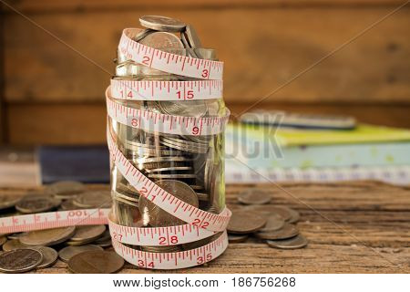 stack of coins and measuring tape for save money concept.
