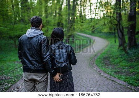 man tocuhs womans ass while walking in city park