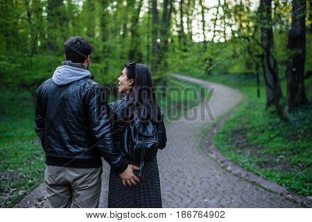 man tocuhs womans ass while walking in city park