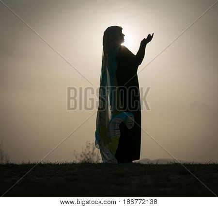 Woman with her hands up on sunset