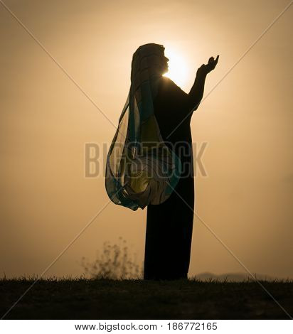 Woman with her hands up on sunset