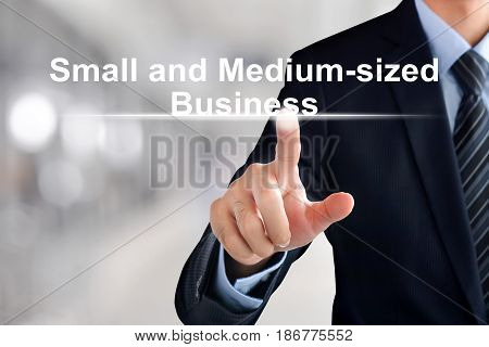Businessman hand touching Small and Medium-sized Business (or SMB) text on virtual screen