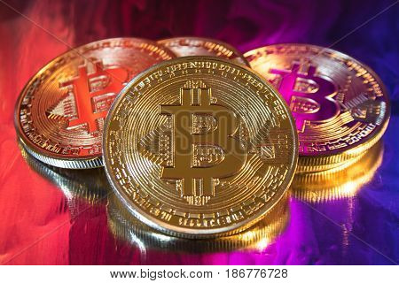 Photo of cryptocurrency physical golden bitcoin coin on colorful background