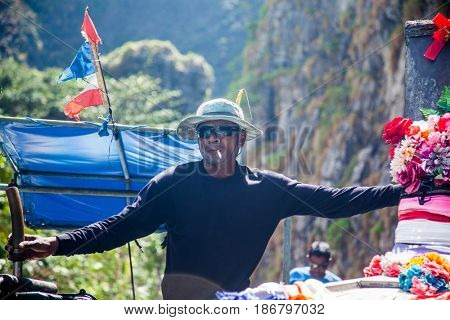 KRABI, THAILAND, February 1, 2014: Traditional long tail boatman on the beach of Ko Phi Phi Leh, Andaman Sea, famous tourist destination in the Ko Phi Phi achipelago