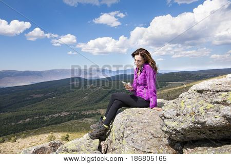 Woman On Top Of Mountain Watching Mobile Phone